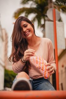 微笑的女人拿着白色和橙色的塑料袋