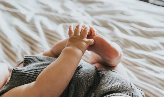 婴儿穿着灰色衬衫躺在床上 婴儿穿着灰色衬衫躺在床上