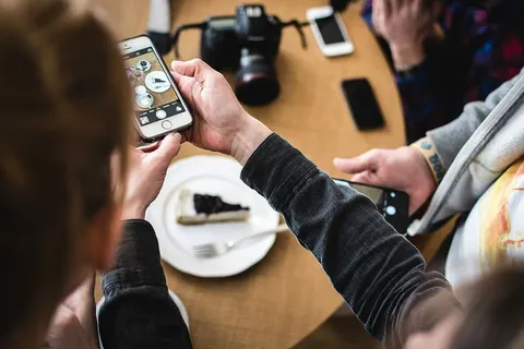 用iPhone拍摄蛋糕的女孩 用iPhone拍摄蛋糕的女孩