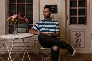 坐在椅子上面向侧面的男子