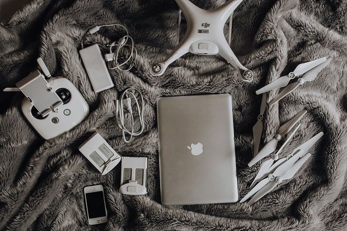 无人机、笔记本电脑和配件躺在床上准备旅行