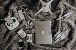 无人机、笔记本电脑和配件躺在床上准备旅行