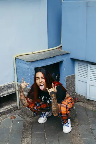 蹲在人行道上吐舌头的女人