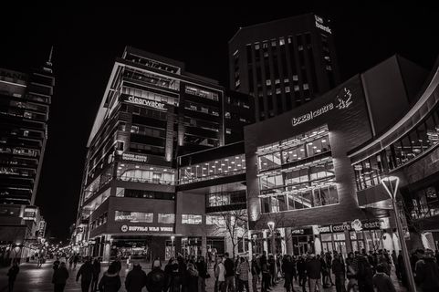 人们在建筑物外行走的灰度照片