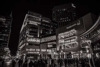 人们在建筑物外行走的灰度照片