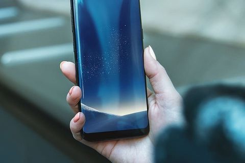 拿着智能手机的女人。高分辨率照片逼真的Galaxy S8 PSD模型。