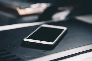 黑色木质表面带黑色外壳的iPhone