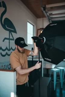 触摸软盒的人，人，人，三脚架，照明，相机，服装，帽子