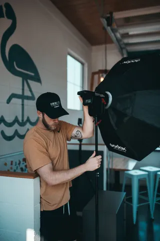 触摸软盒的人，人，人，三脚架，照明，相机，服装，帽子