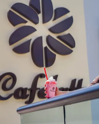 拿着草莓冷饮的人，上面撒着鲜奶油