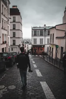 在房屋附近的道路上行走的男子 在房屋附近的道路上行走的男子