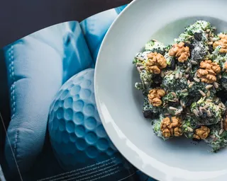 在打开的书本上的圆形白色陶瓷板上烹制的菜肴