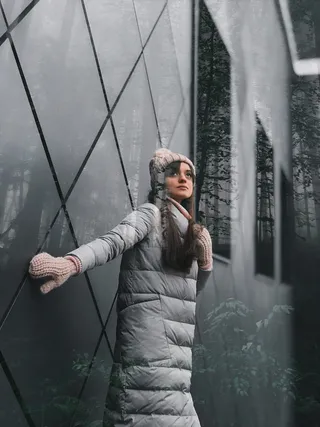 穿着白色泡泡夹克、针织帽子和手套的女士