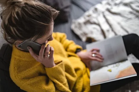 躺在床上看杂志的年轻女子