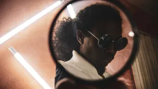 透过镜子看到戴嬉皮太阳镜的男子