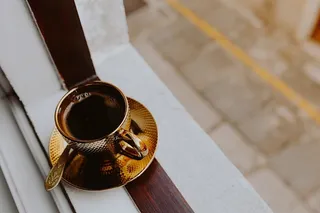 在窗前的金杯里喝咖啡