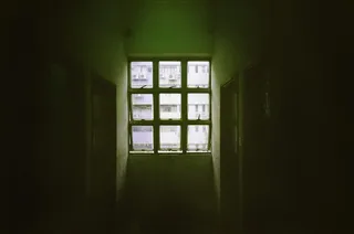 阳光照射在黑暗房间的 6 窗格窗户上