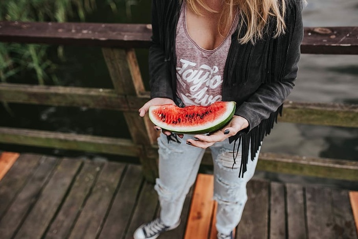 金发女人在木码头吃健康零食