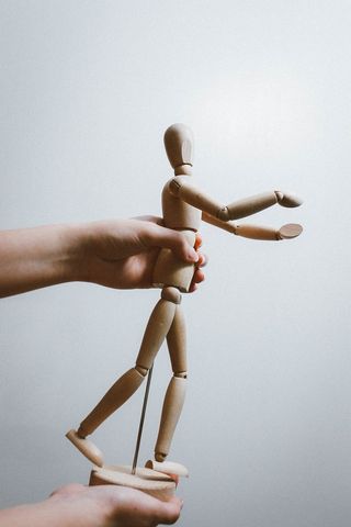 拿着棕色艺术家人体模型的人