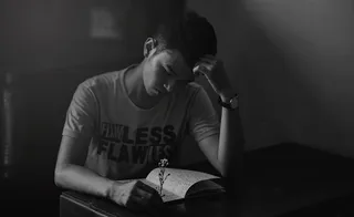 穿着衬衫的男人阅读笔记本的灰度照片