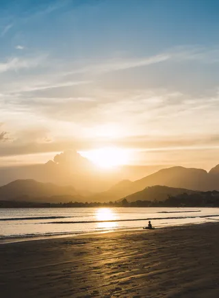 黄金时段坐在海滩上的人