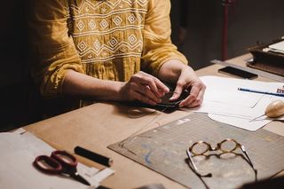 坐在桌子旁拿着黑箱子的人