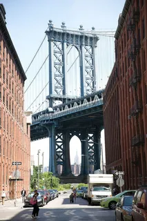 从一条街道上繁忙的街区俯瞰曼哈顿大桥 从一条街道上繁忙的街区俯瞰曼哈顿大桥