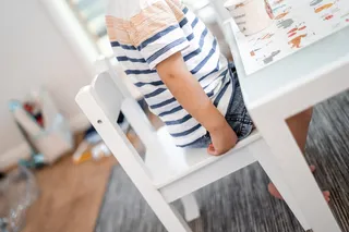 坐在桌子旁白色椅子上的孩子