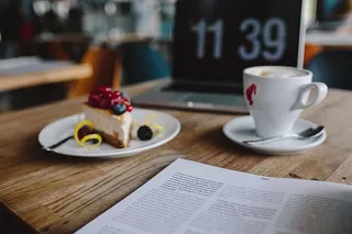 在餐厅工作：Macbook、奶酪蛋糕和一杯咖啡