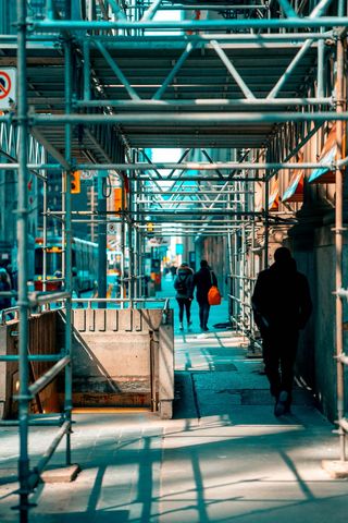 在脚手架下行走的人