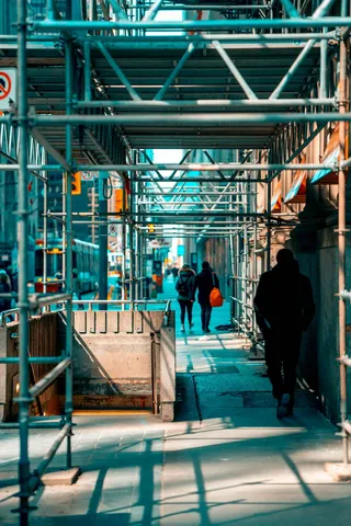 在脚手架下行走的人