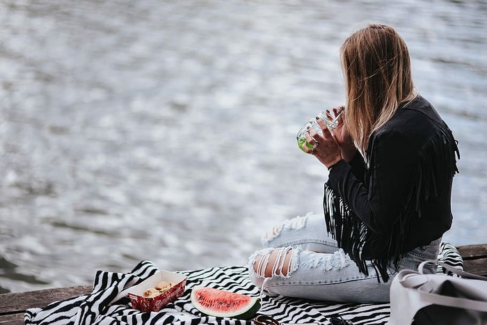 金发女人在木码头吃健康零食