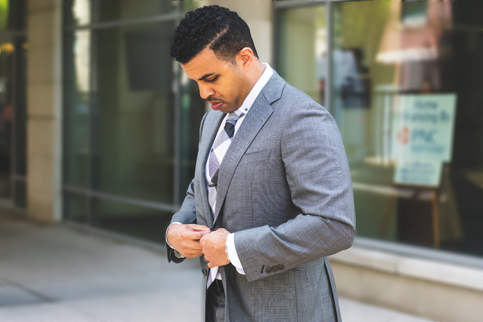 身穿灰色开叉翻领西装夹克的男子