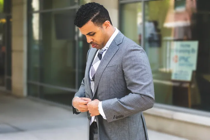 身穿灰色开叉翻领西装夹克的男子