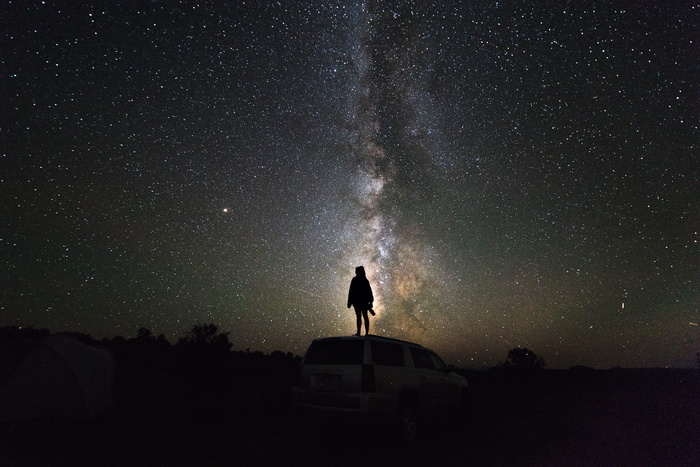 夜间站在白色SUV上的人