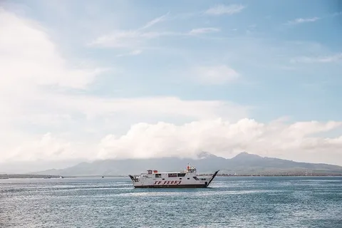 白色渡轮在清澈湛蓝的海水中环绕着群山 白色渡轮在清澈湛蓝的海水中环绕着群山