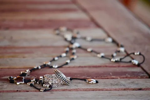 棕色木质表面上的黑白串珠项链