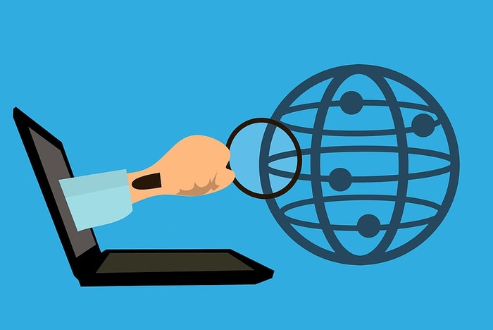使用放大镜和笔记本电脑进行网络搜索的插图。