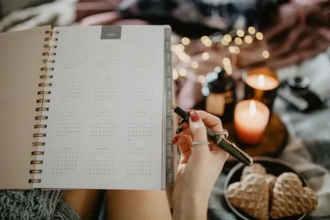 躺在床上的笔记本上写东西，里面有咖啡、蜡烛和姜饼