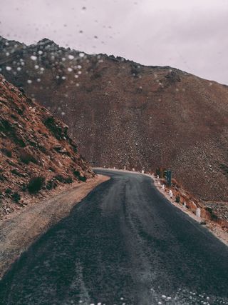 棕色岩层旁的黑色沥青路