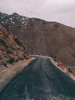 棕色岩层旁的黑色沥青路