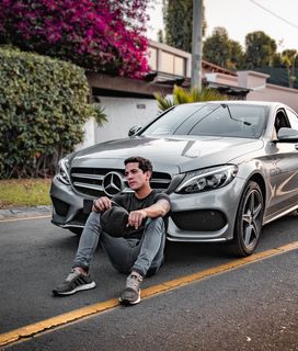 未知名人坐在银色奔驰车旁