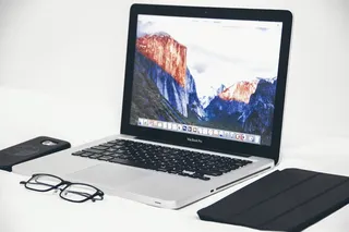 眼镜旁的Macbook Air和黑色智能手机壳