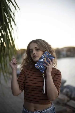 这张照片是一名穿着紧身上衣的女子把脸捏在手包里