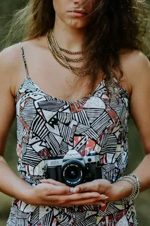 穿着裙子拿着相机的女人