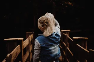 一个穿着蓝色背心拿着头发的女人