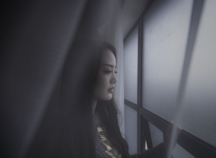 女人望窗外的浅焦摄影