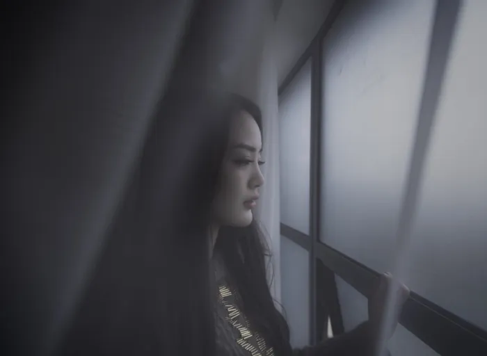 女人望窗外的浅焦摄影