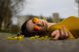 一名女子躺在灰色人行道上的特写照片