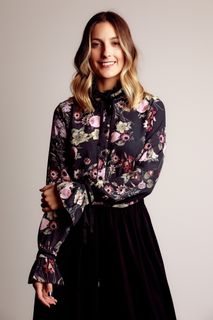 微笑的女人站着左手握着右手